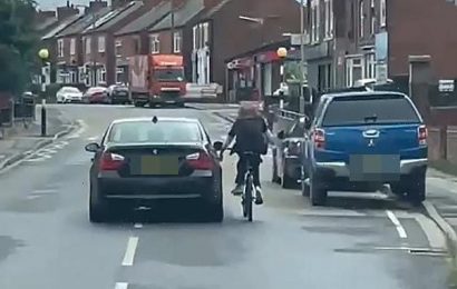 Cyclist crashes onto the road after hitching a ride