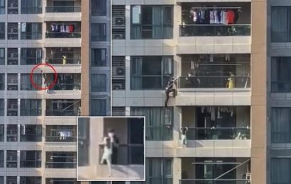 Nail-biting moment policeman lowers himself off high-rise balcony