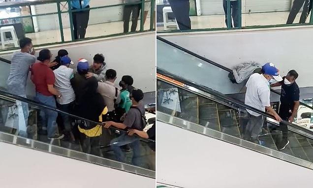 Shop worker gets his HEAD stuck in an escalator at Indonesian mall