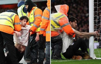 Arsenal's clash against Liverpool stopped after pitch invader HANDCUFFS himself to goal post