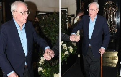 Michael Caine, 89, clutches onto bodyguard and walking stick for support on date with wife