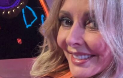 Carol Vorderman flaunts figure in sheer dress and rolls on bed with Johnny Vegas